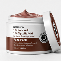 A jar of Dermistry Face Pack instant tan removal cream with its lid leaning against it, showing the brown cream inside. The label is white and brown with text detailing the ingredients: 1% Kojic Acid and 1% Glycolic Acid.