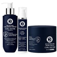 Three Derivatives CCA Root System Hair Fall Control products on a white background: a large navy shampoo bottle with a white pump, a smaller serum bottle with a clear cap, and a navy hair mask jar.
